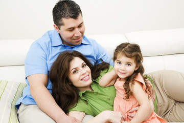 portrait of happy family sitting on sofa at home