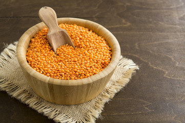 Red dry lentils in a bamboo bowl.