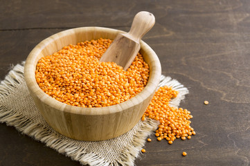 Red dry lentils in a bamboo bowl.