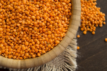 Red dry lentils in a bamboo bowl.