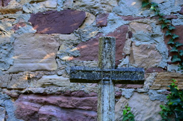 Steinkreuz vor Mauer