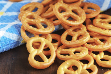 Traditional German pretzels on blue towel on dark wood background top view with copy space. Oktoberfest food concept 