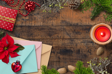 weihnachtliche Dekoration und Briefumschläge auf Holzuntergrund