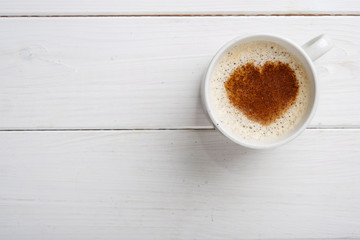 coffee with cinnamon heart shaped on white wood table top view with copy space for text. Valentines day concept 