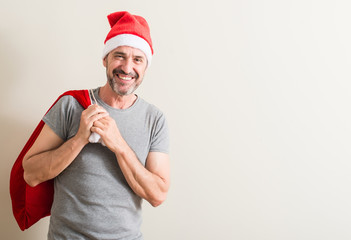 Senior man wearing christmas santa claus hat with a happy face standing and smiling with a confident smile showing teeth