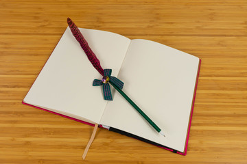 Hand writing books wallet and notebook placed on a wooden table. top view image of open notebook with blank pages next to cup of coffee on wooden table. Notepad with pencil on the wood background.