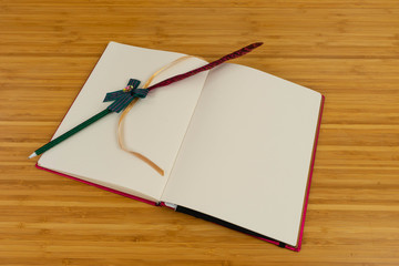 Hand writing books wallet and notebook placed on a wooden table. top view image of open notebook with blank pages next to cup of coffee on wooden table. Notepad with pencil on the wood background.