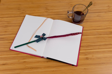 Hand writing books wallet and notebook placed on a wooden table. top view image of open notebook with blank pages next to cup of coffee on wooden table. Notepad with pencil on the wood background.