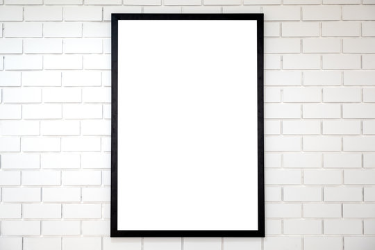 A blank black wooden picture frame on white brick wall background