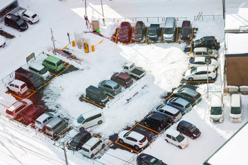 Car parking with snow lot viewed from above, bird eye view