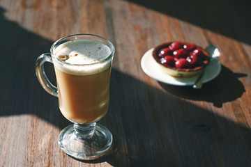 cappuccino coffee cup and cherry dessert on background in morning on wood table