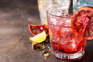 Red cocktail with blood orange Refreshing summer drink on stone or concrete background. Holiday...