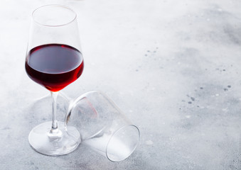Elegant glasses of red wine on stone kitchen table background.