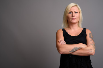 Portrait of woman with blond hair against gray background