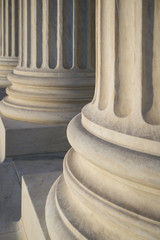Close-up of Neo-Classical fluted columns at the Supreme Court building in soft sunset light in...