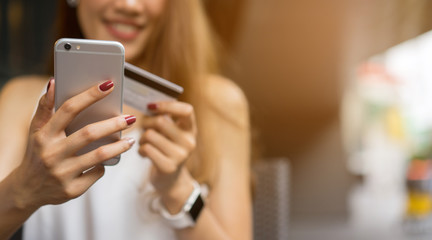 close up asian business woman holding smartphone with credit card for pay online shopping e-commerce concept