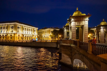 Brightly lit Lomonosov Bridge and Lomonosov Square at night in St. Petersburg. Russia