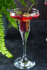 Delicious cocktails with campari, gin, vermouth, and a berries. Refreshing summer drink on stone or concrete background. Holiday aperitif for Christmas party.