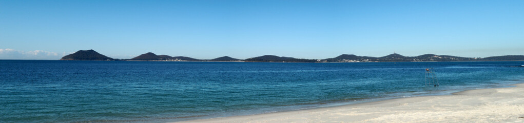 Fototapeta premium Panorama of a white sand beach and mountains