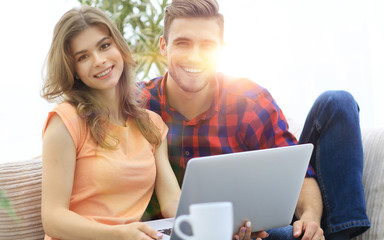 young couple .working on laptop sitting on sofa