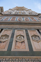 Duomo. Santa Maria del Fiore Cathedral in Florence, Italy. Fragment of bell tower on blue sky background.