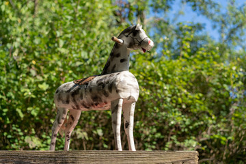 Vintage Holzpferd auf Holzbrett mit Rädern in der Natur von unten