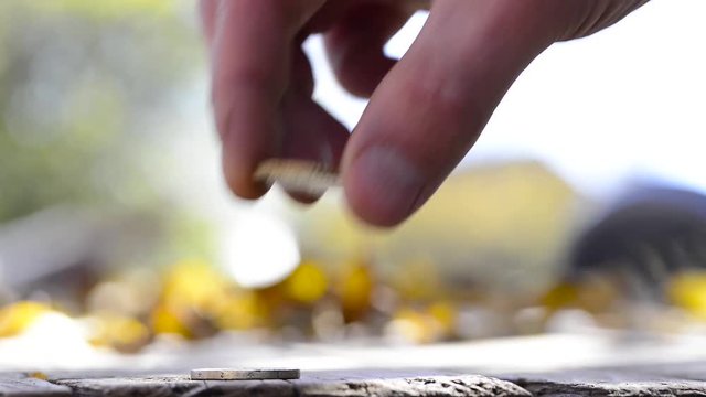 Hard working caucasian male hand with wounds counting hes last coins on wooden table outdoor, conceptual footage of underpaid work.