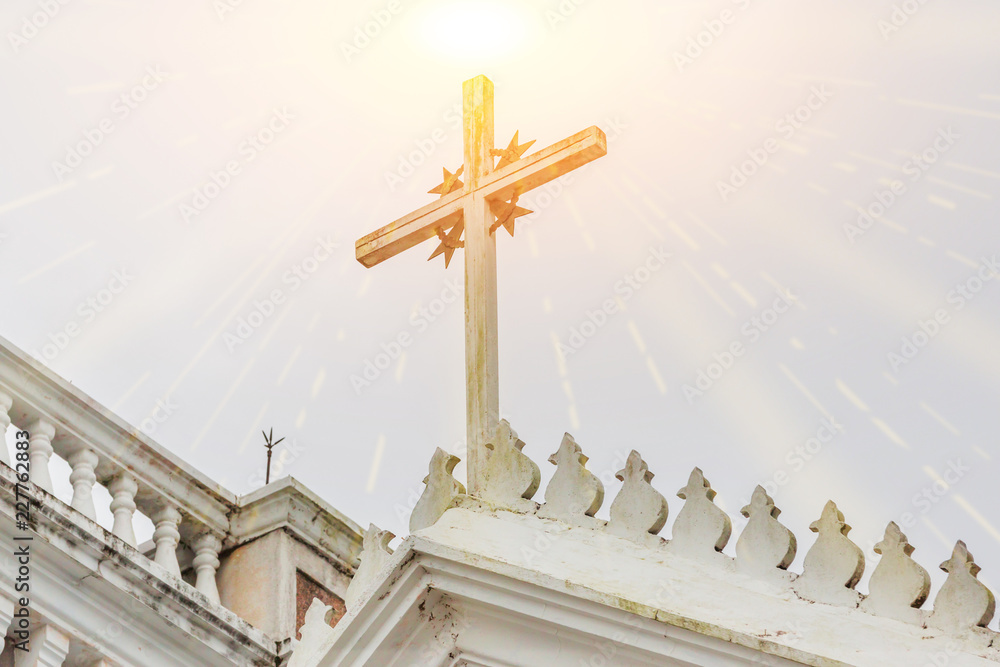 Wall mural the cross on a church with sunlight