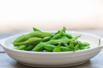 closeup view Soybean pods on white dish in the nature background
