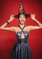 Beautiful young surprised woman in witches hat. Pretty young blonde woman dressed as fairy. Elegant...