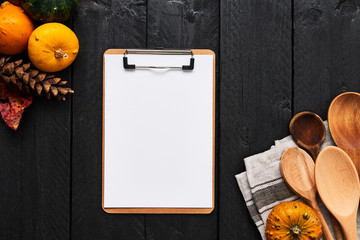 Autumn vegetables cooking preparation. Pumpkins, wooden spoons and blank paper on cardboard...