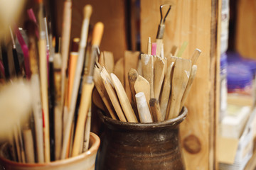 Set of brushes and painting tools on table in artist's workshop