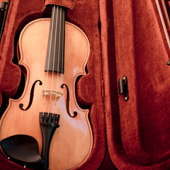 Fototapeta premium Violin and bow in dark red case. Close up view of violin
