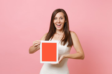 Fototapeta na wymiar Portrait of excited bride woman in wedding dress hold tablet pc computer with blank black empty screen isolated on pastel pink background. Wedding to do list. Organization of celebration. Copy space.