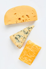 Different cheese types on light background. Maasdam cheese, french gorgonzola cheese and marble cheese. Delicious dairy products for gourmet.