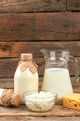 Dairy products on vintage wooden background. Milk, cottage cheese, sour cream and piece of Dutch...