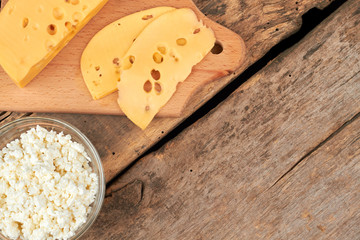 Dutch cheese and cottage cheese on wooden background. Healthy dairy products and copy space. Organic eating concept.