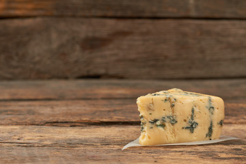 Blue cheese Gorgonzola on a rustic wooden background. French musty cheese and copy space. Tasty food for gourmet.