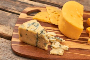 Cheese platter on wooden background. Piece of French roquefort cheese with mold. Taste of perfection.