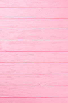 Wooden textured background. Pink striped wooden boards, vertical image. Painted wooden wall close up.