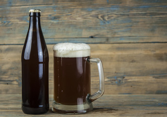 bottle and glass with beer on wood table