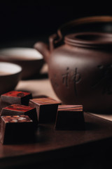 Sweets on brown plate with cup of tea on the beckground.