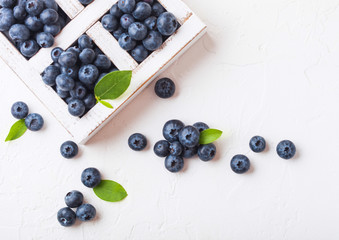 Fresh raw organic blueberries with leaf in vintage wooden box on stone kitchen background. Top view. Space for text