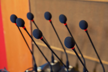 Detail of a head of a microphone on a speaker desk on a konference. Concept of speaking before audience on a corporate event.