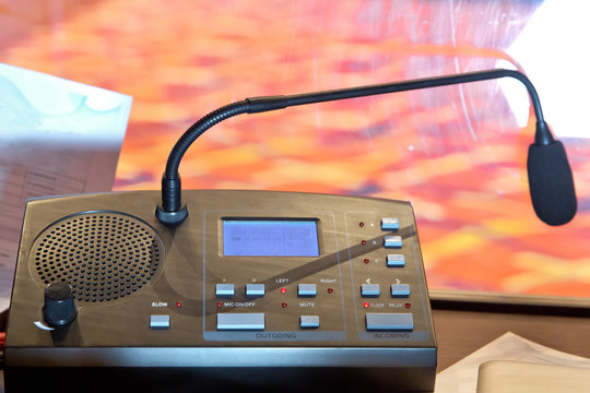 Translator room . translators cubicle . interpreting - Microphone and switchboard in an simultaneous interpreter booth . Soft focus of wireless Conference microphones and notebook in a meeting room.