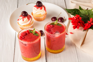 Berry smoothies and cupcakes with cherries