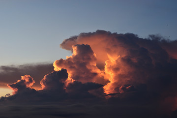 Cumulonimbus cloud formations on tropical sky with horizon is turning yellow at sunset , Nimbus moving , Purple and orange color clouds hunk at night , Thailand

