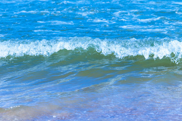 Fototapeta na wymiar Close up view indigo sea with ripples and colorful is beautiful on the sand.