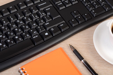 Keyboard with a Cup of coffee and notebook