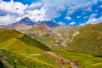 Mount Kazbek beautiful view from Gergeti Trinity Church Tsminda Sameba in summer sanny day. It is a dormant stratovolcano and one of the major mountains of the Caucasus. Gergeti Georgia.